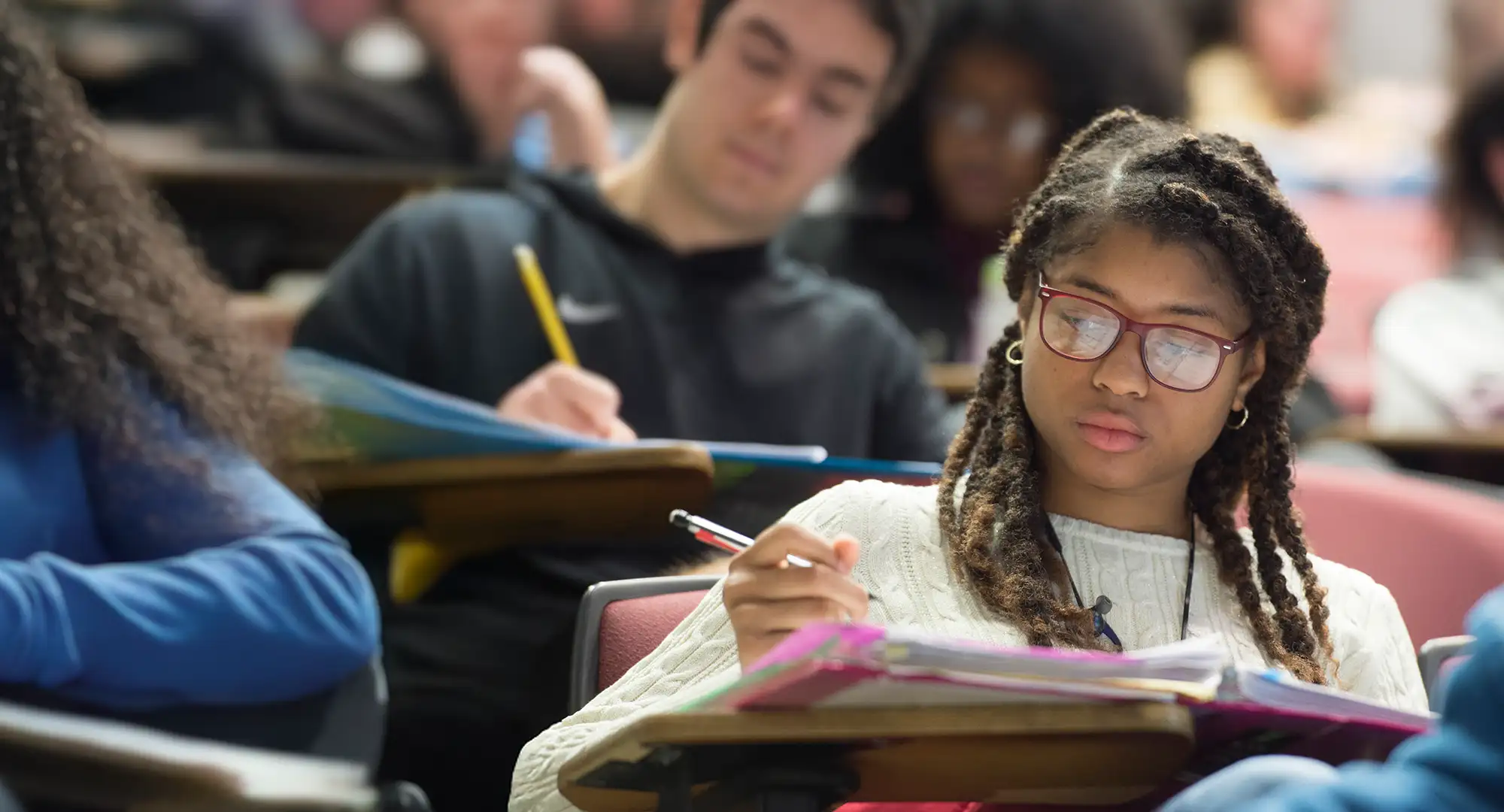Student taking notes in class, focused during a lecture at Southern Illinois University.